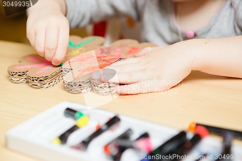 Image of Little female baby painting with colorful paints