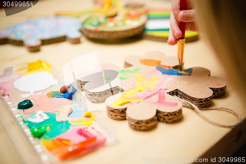 Image of Little female baby painting with colorful paints