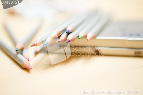 Image of Close up of color pencils over wooden background