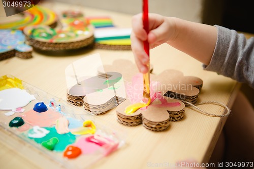 Image of Little female baby painting with colorful paints