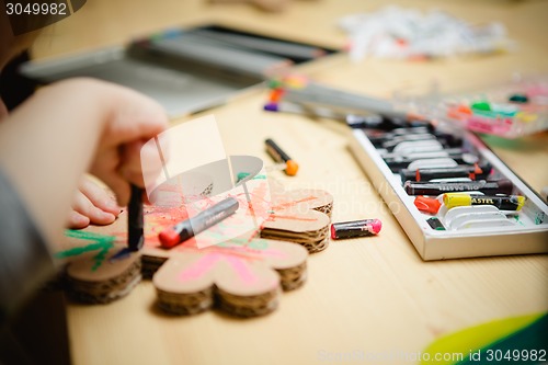 Image of Little female baby painting with colorful paints