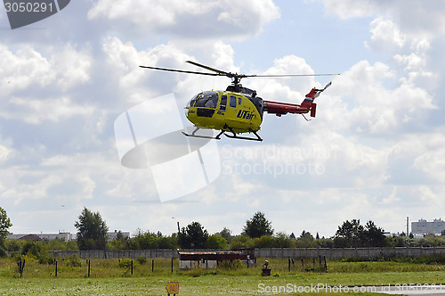 Image of The small yellow helicopter of Utair airline in the sky.