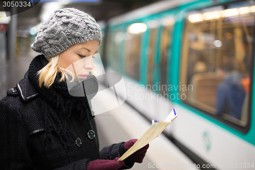 Image of Lady waiting on subway station platform.