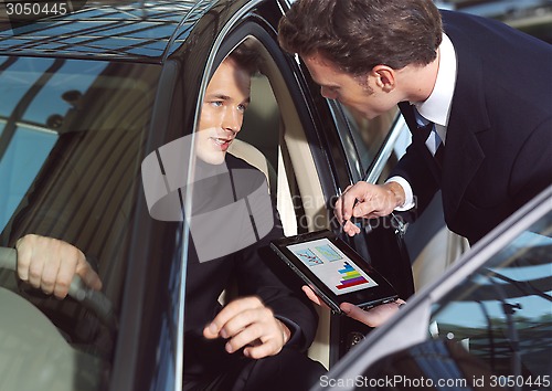 Image of businesmen working inside a car