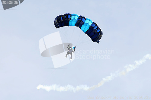 Image of the parachutist goes down on a multi-colored parachute.