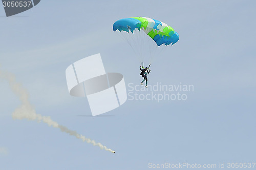 Image of the parachutist goes down on a multi-colored parachute.