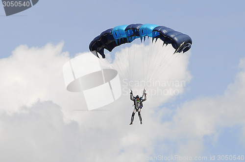Image of the parachutist goes down on a multi-colored parachute.