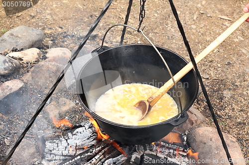 Image of black cauldron on camping fire