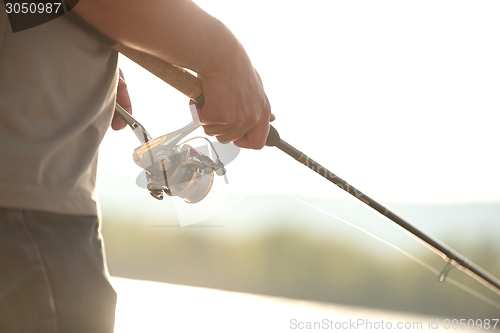 Image of Modern clean fishing rod in hands