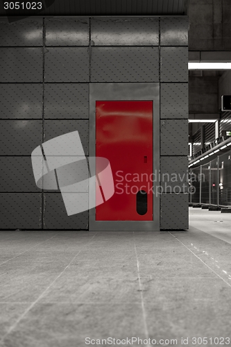 Image of Gray steel wall with the red door
