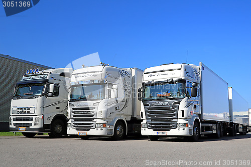 Image of Fleet of White Scania and Volvo Trucks on a Yard