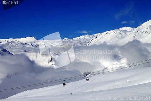 Image of Off-piste snowy slope and cable car at nice day