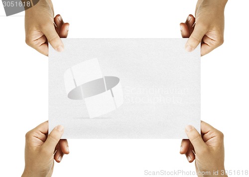 Image of four hands holding sheet of paper
