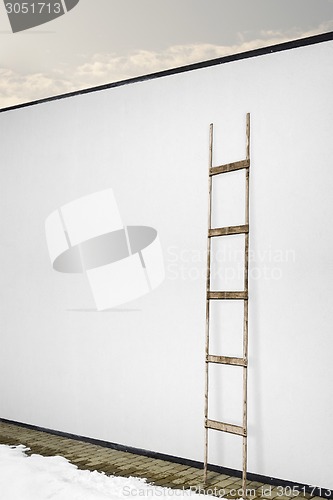 Image of white wall with a wooden ladder