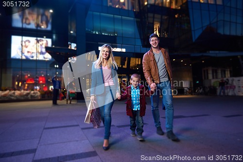 Image of happy family walking with shopping bag