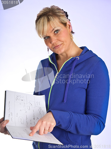 Image of Studio portrait of a cute blond girl reading in a book