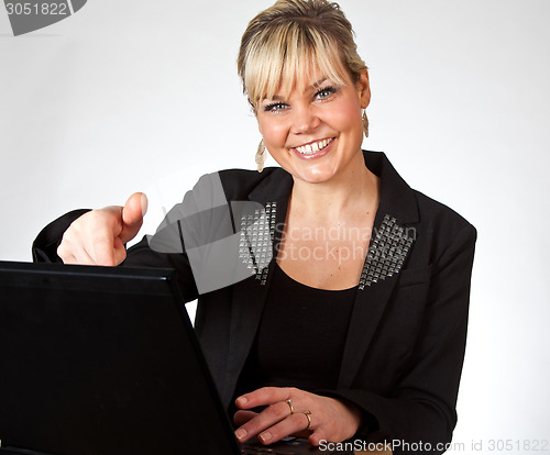 Image of Studio portrait of a cute blond girl with a computer