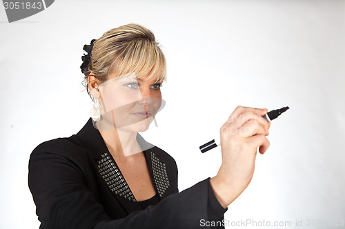 Image of Studio portrait of a cute blond girl writing on a transparent wa