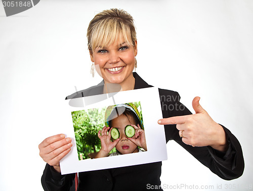 Image of Studio portrait of a cute blond girl holding a piece of paper