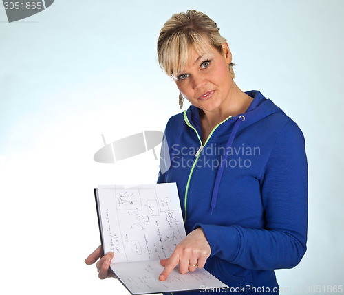 Image of Studio portrait of a cute blond girl reading in a book