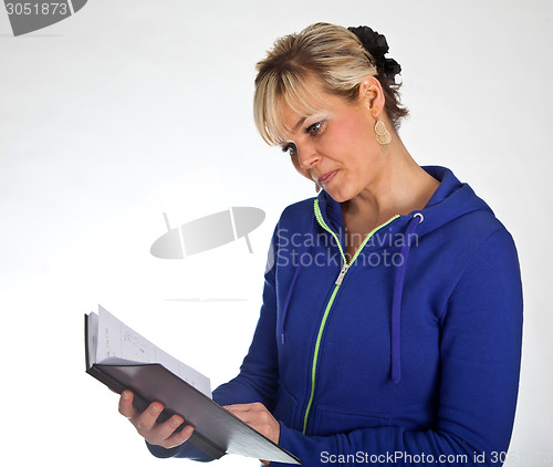 Image of Studio portrait of a cute blond girl reading in a book
