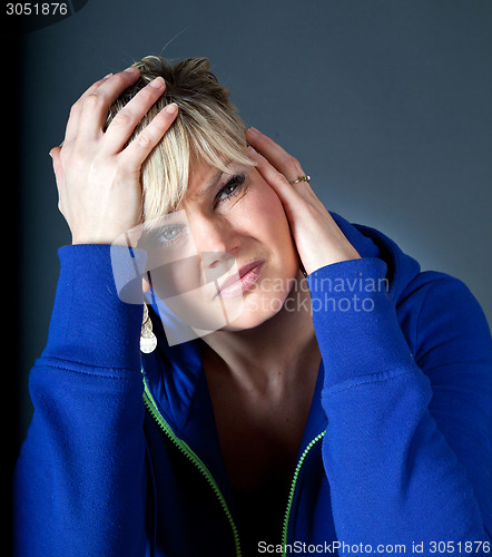Image of Cute blond girl with head in hands