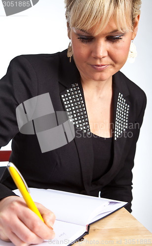 Image of Studio portrait of a cute blond girl writing