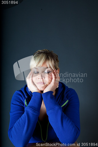 Image of Cute blond girl with head in hands
