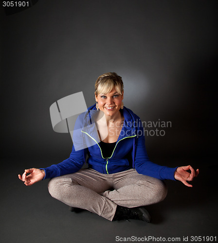 Image of Studio portrait of a cute blond girl in a meditation position