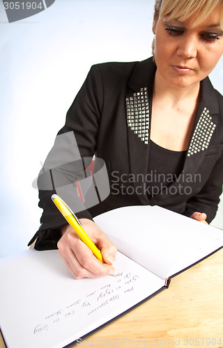 Image of Studio portrait of a cute blond girl writing