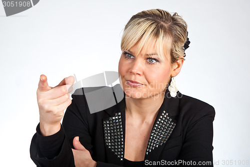 Image of Studio portrait of a cute blond girl pointing with her finger