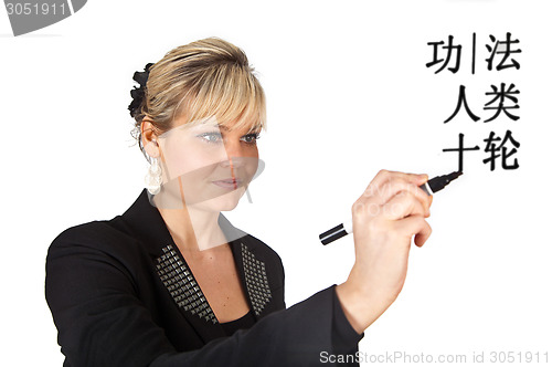 Image of Studio portrait of a cute blond girl writing on a transparent wa