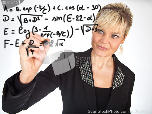 Image of Studio portrait of a cute blond girl writing on a transparent wa