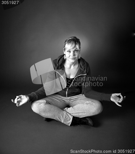Image of Studio portrait of a cute blond girl in a meditation position