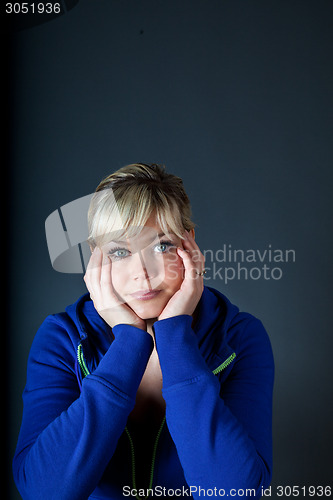 Image of Cute blond girl with head in hands