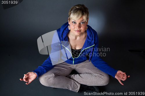 Image of Studio portrait of a cute blond girl in a meditation position
