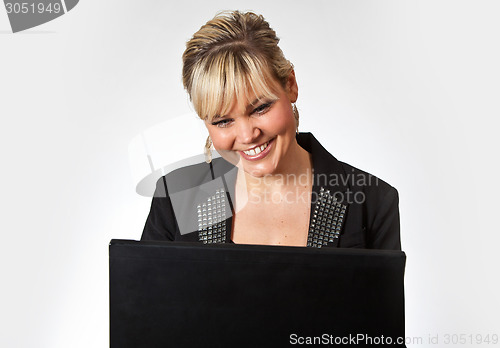 Image of Studio portrait of a cute blond girl with a computer