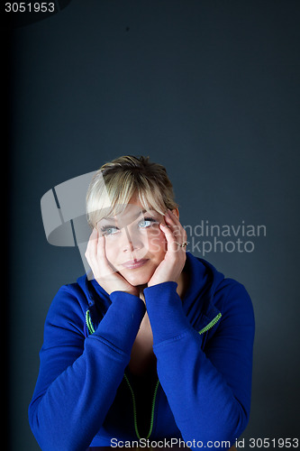 Image of Cute blond girl with head in hands