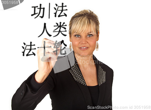 Image of Studio portrait of a cute blond girl writing on a transparent wa