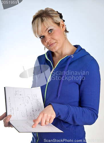 Image of Studio portrait of a cute blond girl reading in a book