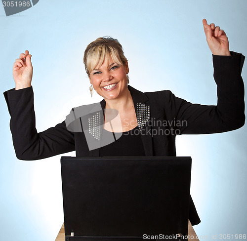 Image of Studio portrait of a cute blond girl with a computer hands up