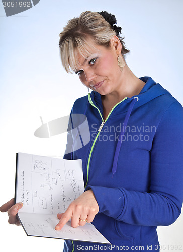 Image of Studio portrait of a cute blond girl reading in a book