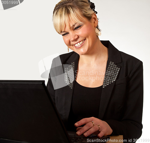 Image of Studio portrait of a cute blond girl with a computer