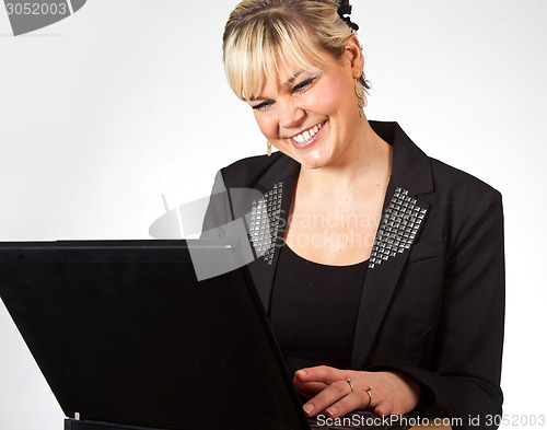 Image of Studio portrait of a cute blond girl with a computer