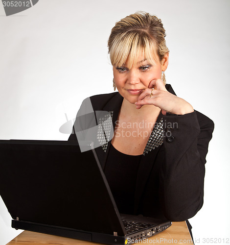Image of Studio portrait of a cute blond girl with a computer
