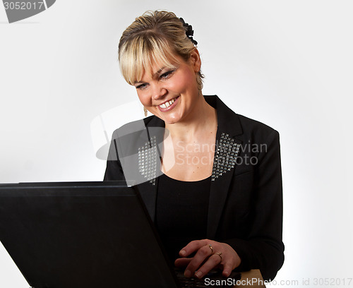 Image of Studio portrait of a cute blond girl with a computer
