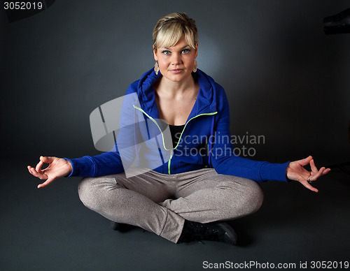 Image of Studio portrait of a cute blond girl in a meditation position