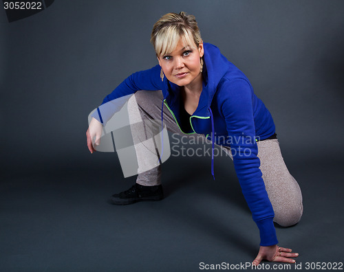 Image of Studio portrait of a cute blond girl one knee on the floor