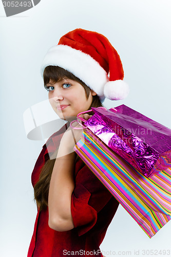 Image of young woman in santa hat with holiday shopping