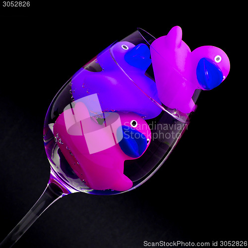 Image of Pink and purple rubber ducks in wineglasses